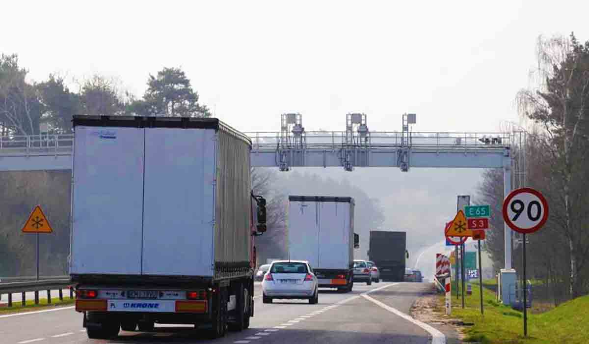 Ciężarówki na autostradzie przejeżdżające pod bramownicą służącą do ewidencji pojazdów