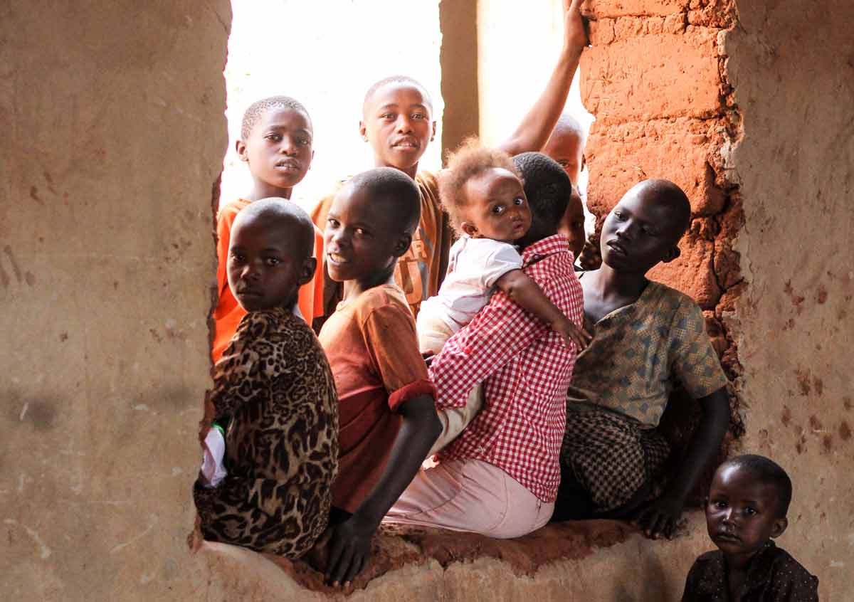 Dzieci w oknie afrykańskiego domu z gliny