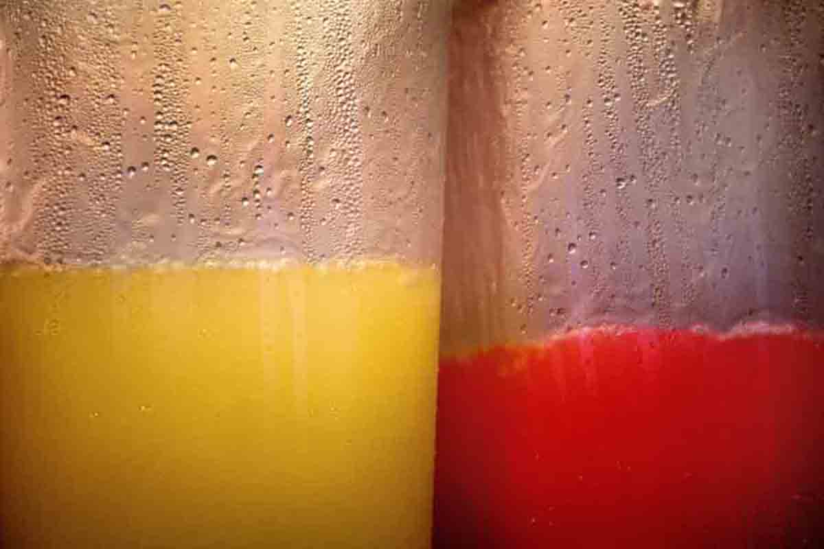 Dwie szklanki soków. Sok koloru czerwonego i żółtego