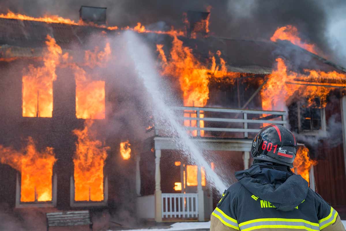 Płonący dom gaszony przez strażaka