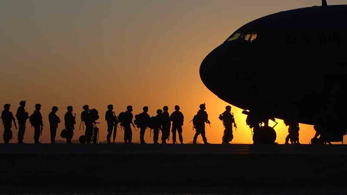 Żołnierze w drodze do samolotu, w tle zachód słońca