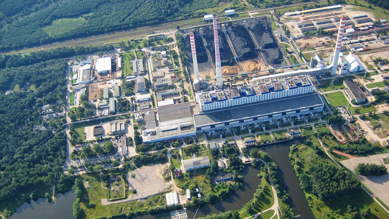 Widok elektrowni Dolna Odra z lotu ptaka, hałdy węgla, kominy i kanał z wodą